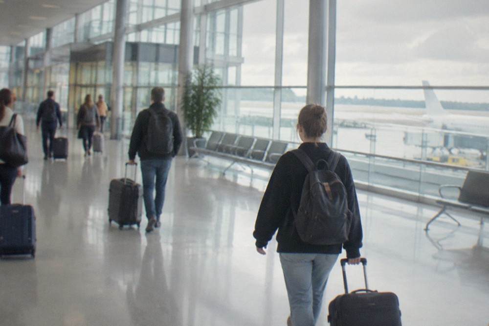 Travellers with suitcases walking through the bright departures hall of a modern French airport terminal