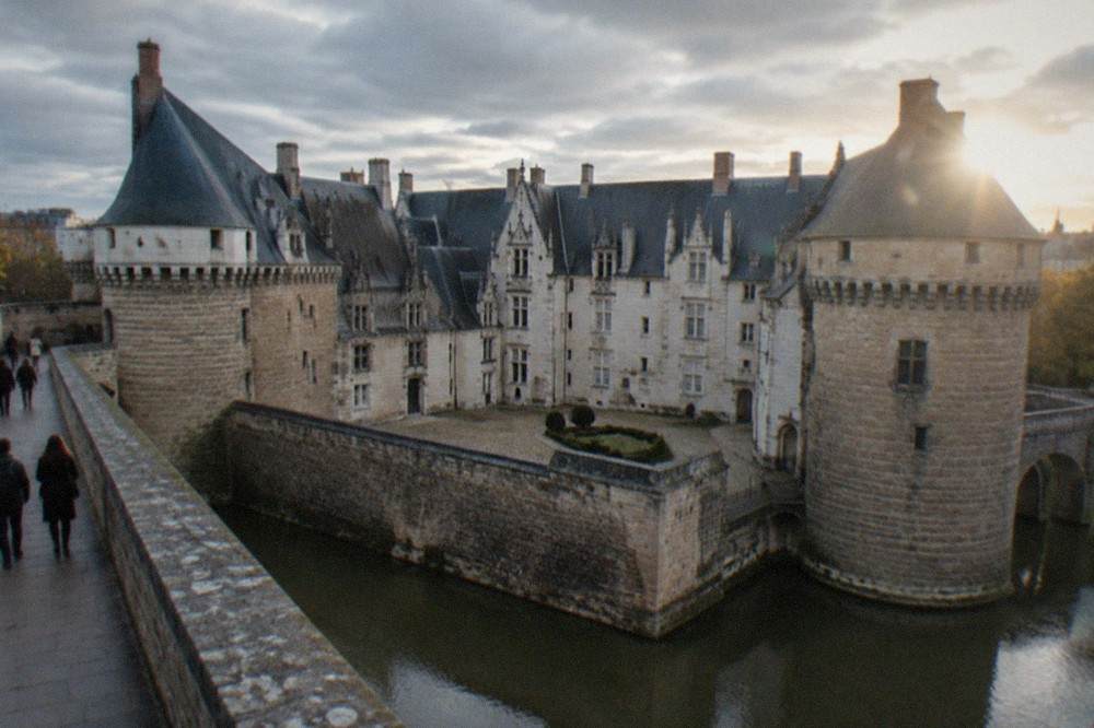Visitors walking along the stone ramparts of the Château des ducs de Bretagne in Nantes