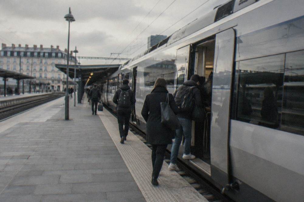 A high-speed train waiting on the platform at Nantes station with passengers boarding