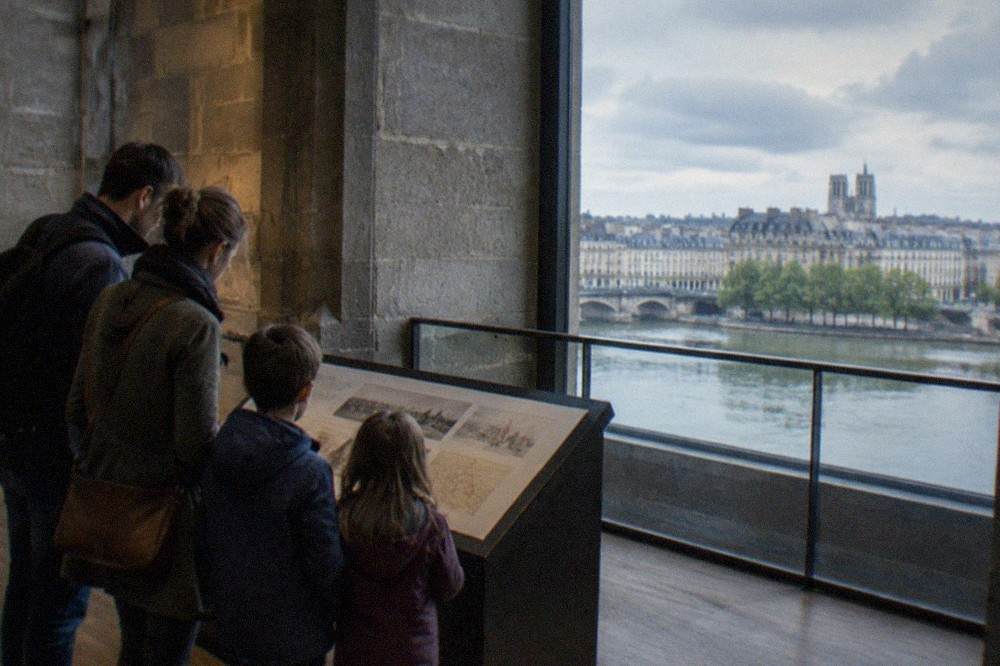 A family reading a bilingual information panel inside the castle museum in Nantes