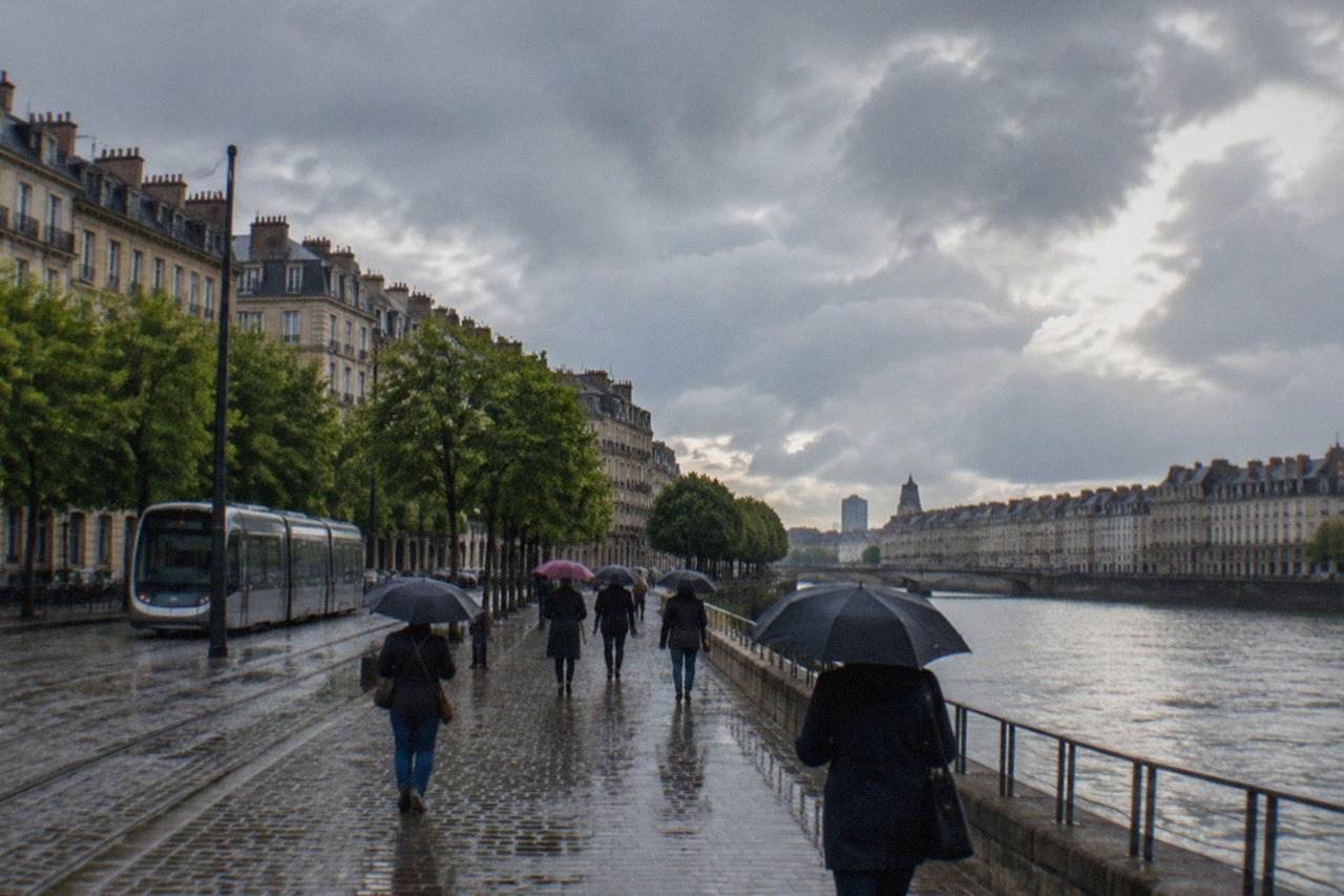 Rainy day on a Nantes street with wet cobblestones and pedestrians under umbrellas