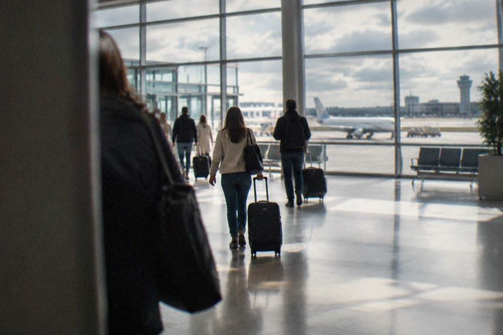 Travellers with suitcases walking through the bright departures hall of a French regional airport