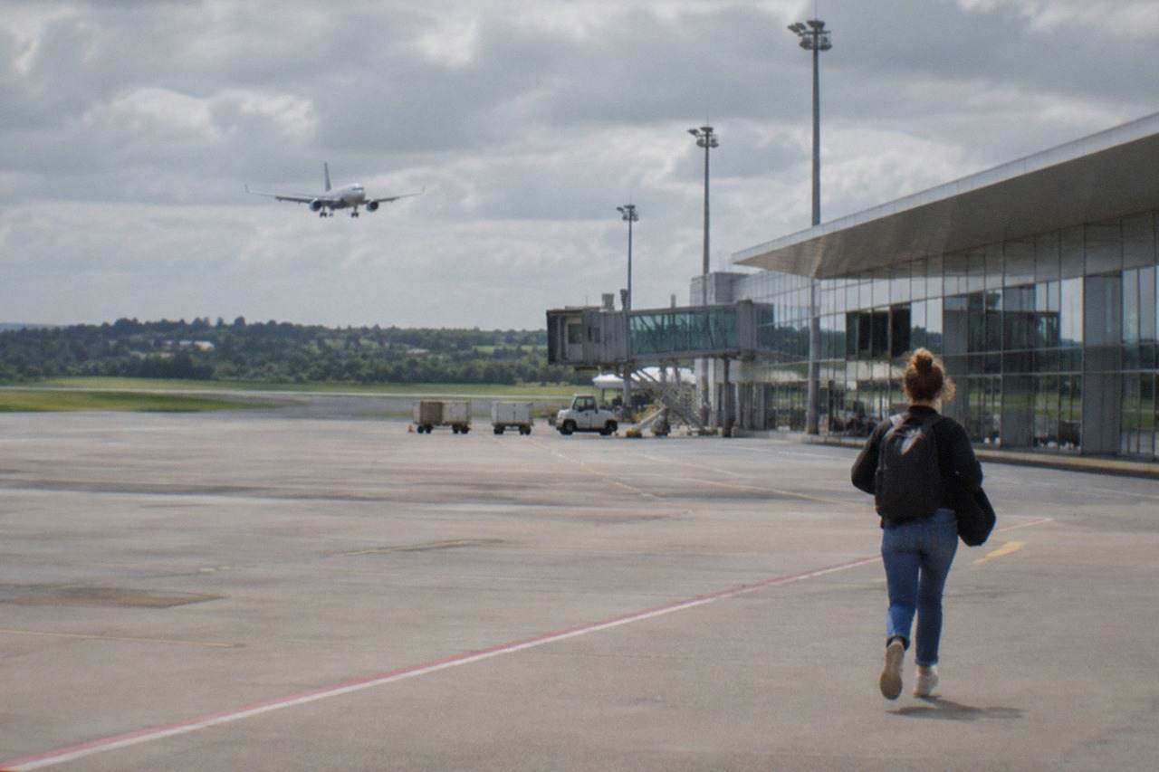 A passenger aircraft descending over green Loire countryside toward the airport southwest of Nantes
