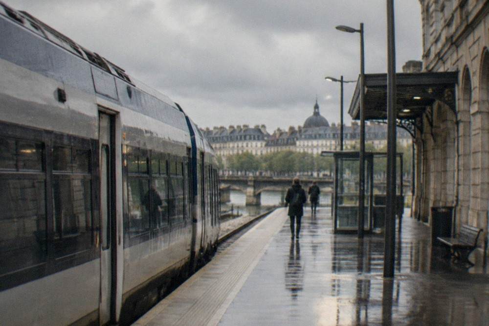 A regional train waiting at a platform beside the stone station building in Nantes