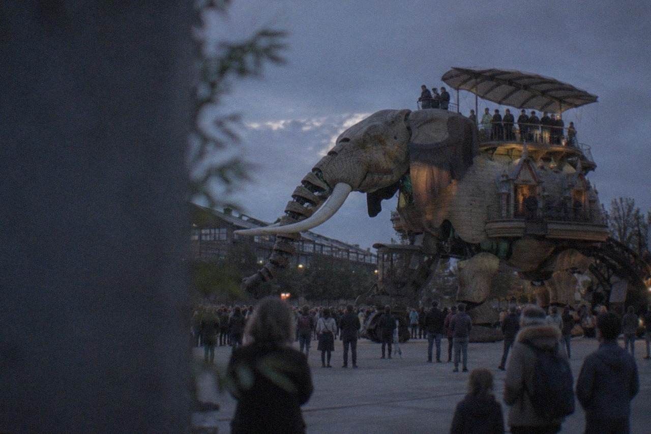 The Grand Éléphant walking machine crossing a plaza on the Île de Nantes with visitors watching
