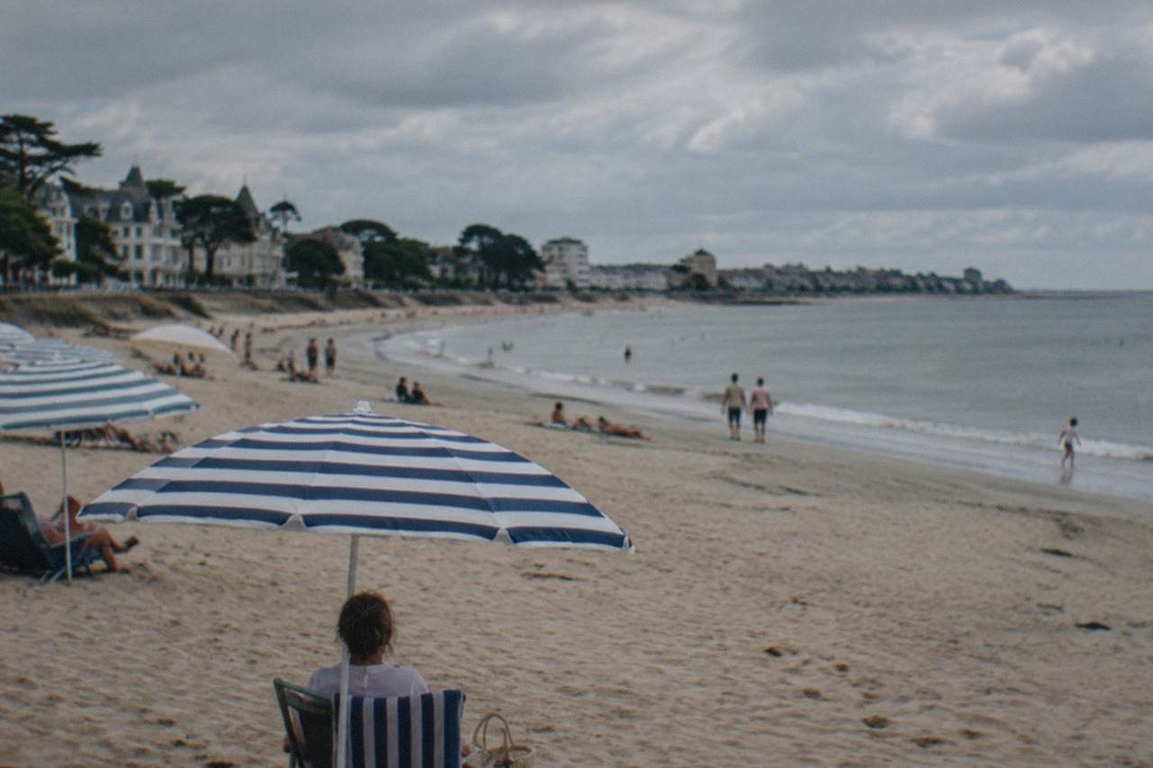 A wide sandy beach at La Baule with parasols and a calm sea under a summer sky