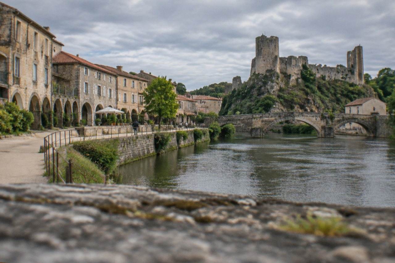 Arcaded stone buildings and a riverside path in the old town of Clisson near Nantes