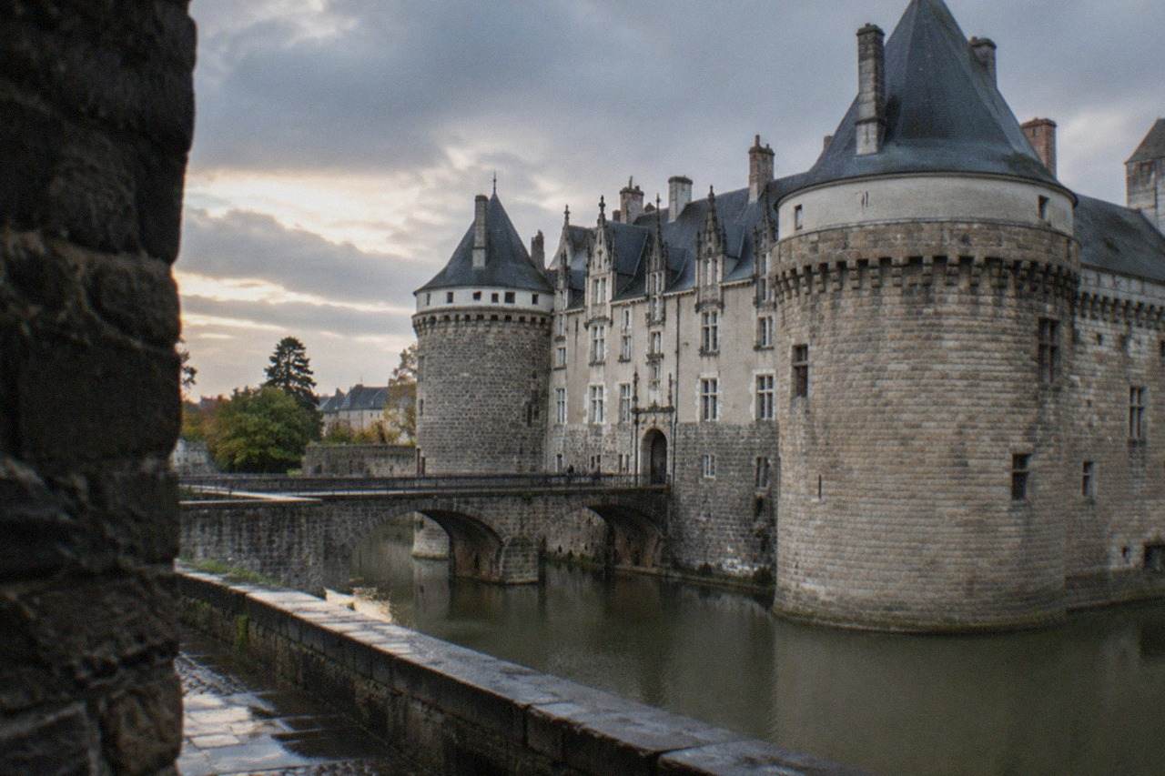 Stone ramparts and slate-roofed towers of the Château des ducs de Bretagne in Nantes at dusk