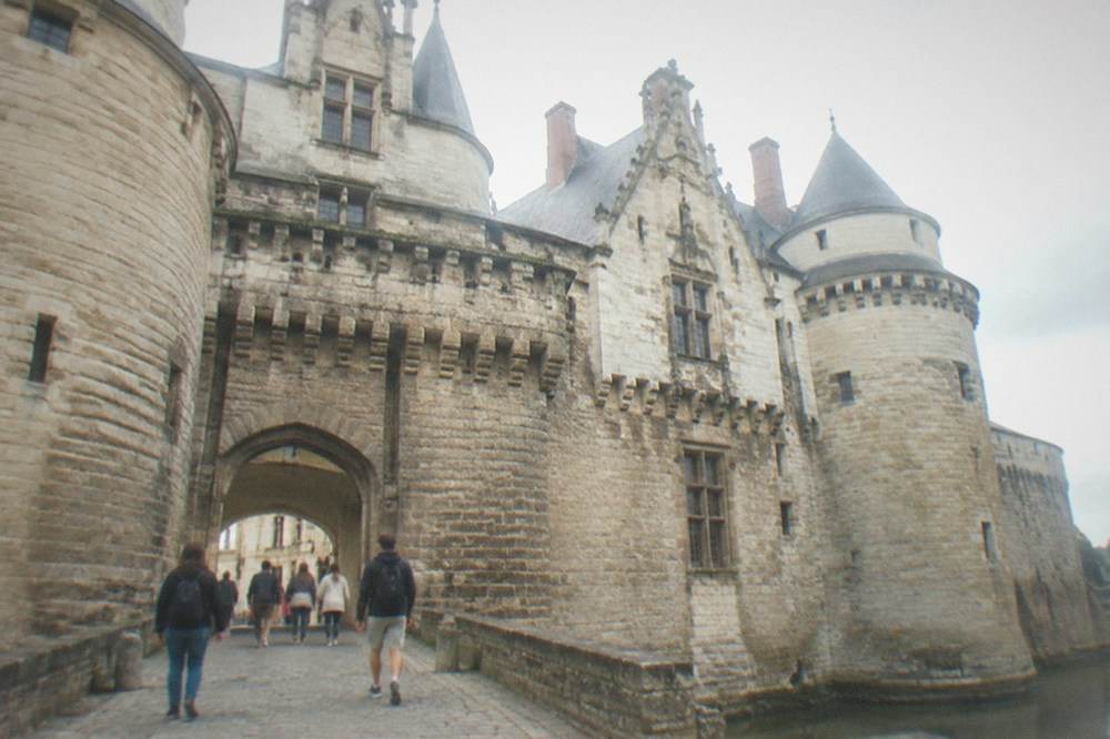 Visitors walking through the stone gateway of the Château des ducs de Bretagne