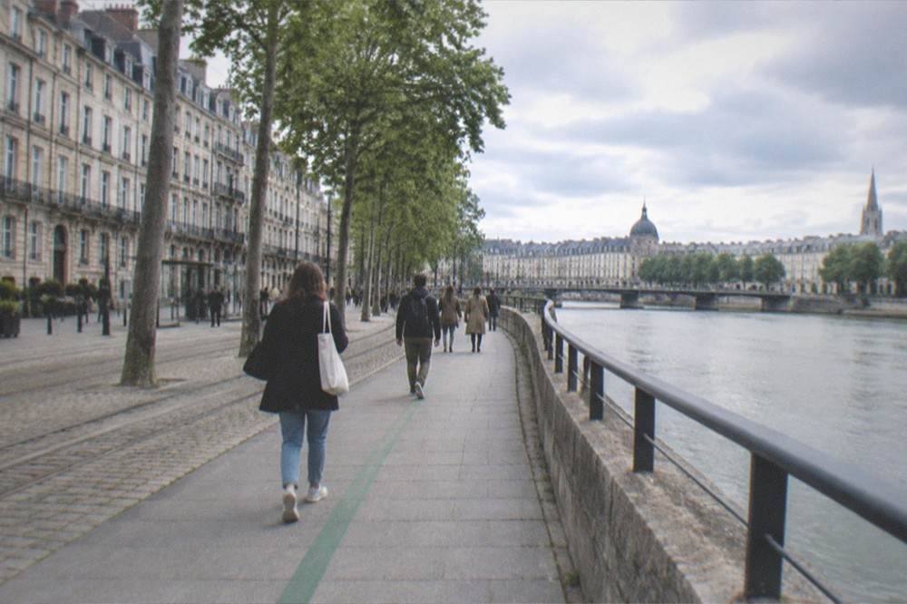 Walkers following a green painted line along a street near the old town of Nantes