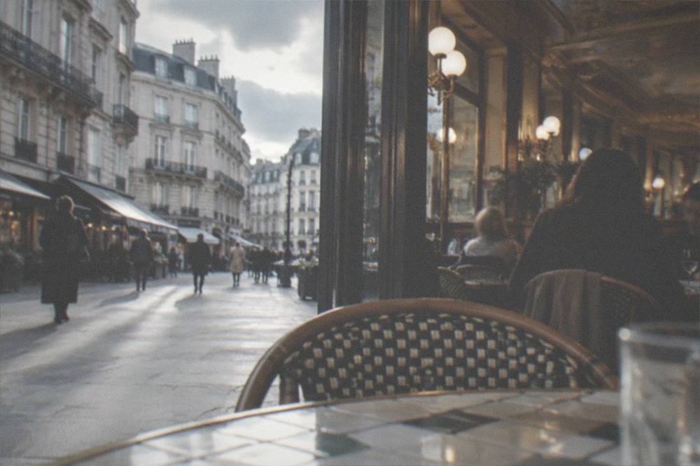 Diners at tiled tables inside an ornate French brasserie with gilded ceilings
