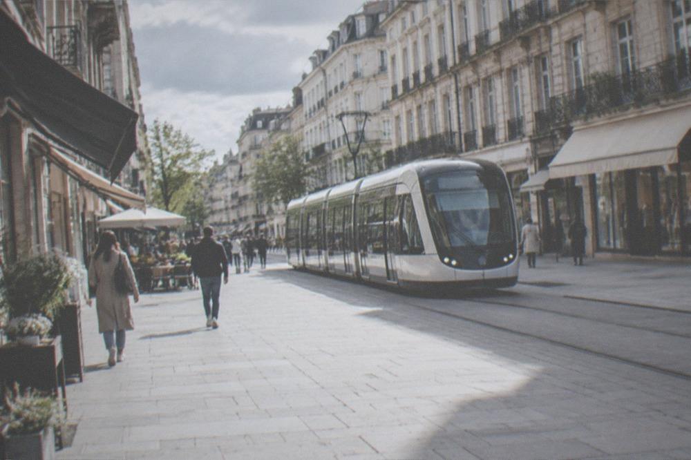 A modern tram gliding along a pedestrian-priority street in a French city centre