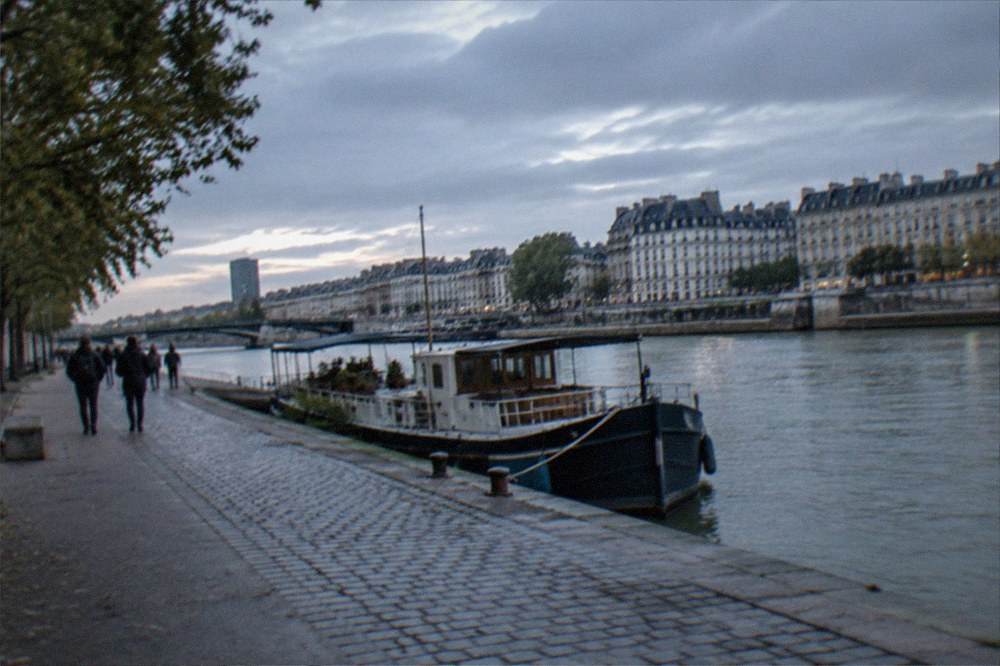 A riverside path in Nantes with a boat moored along the Loire and stone quays in the background