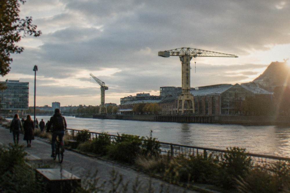 Riverside walkway along the Loire on the Île de Nantes with old industrial cranes in the background