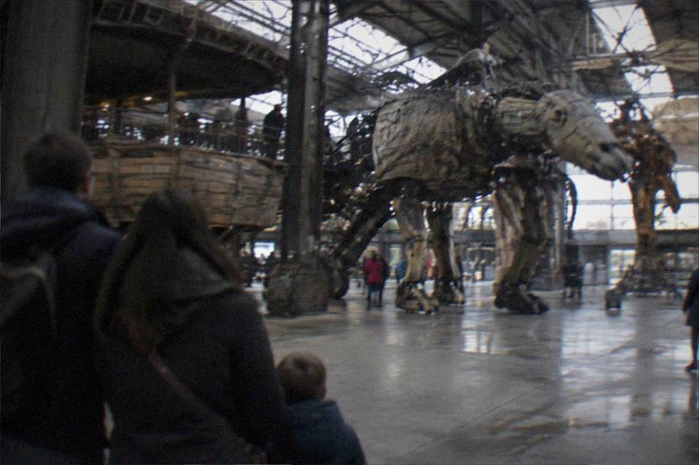 A family watching mechanical machines move inside the Galerie des Machines workshop