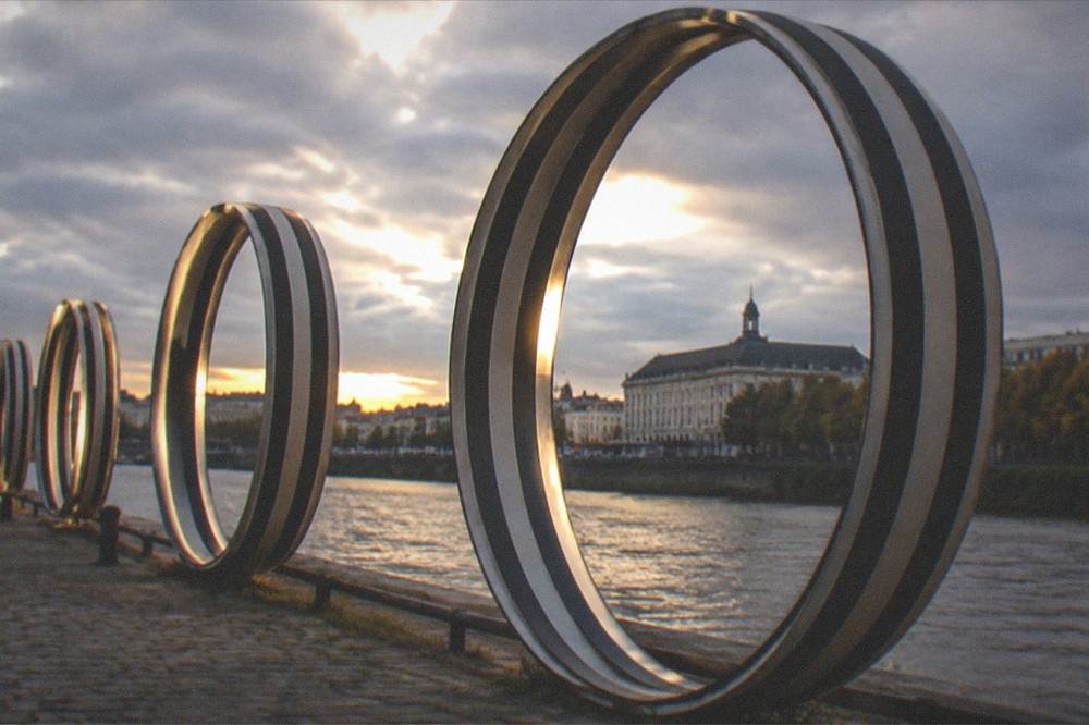 The Anneaux de Buren rings glowing at dusk around the Palais de Justice at the eastern end of the Île de Nantes