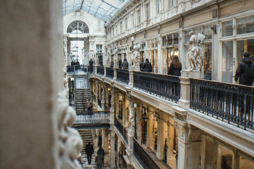 Visitors walking through the ornate 19th-century Passage Pommeraye shopping gallery in Nantes