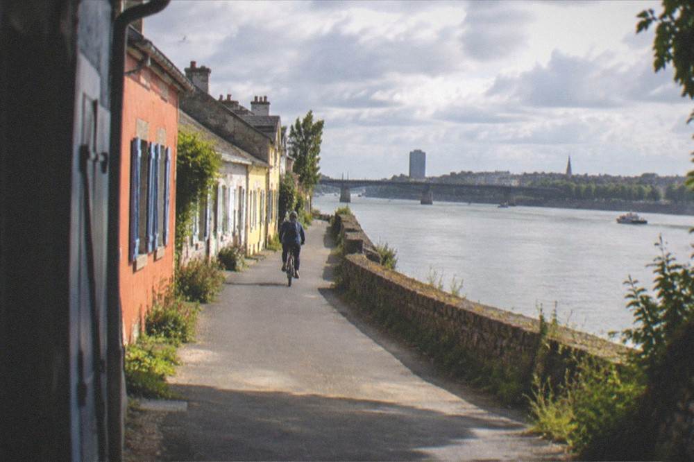 A cyclist riding along the riverside path near Trentemoult with the Loire on one side