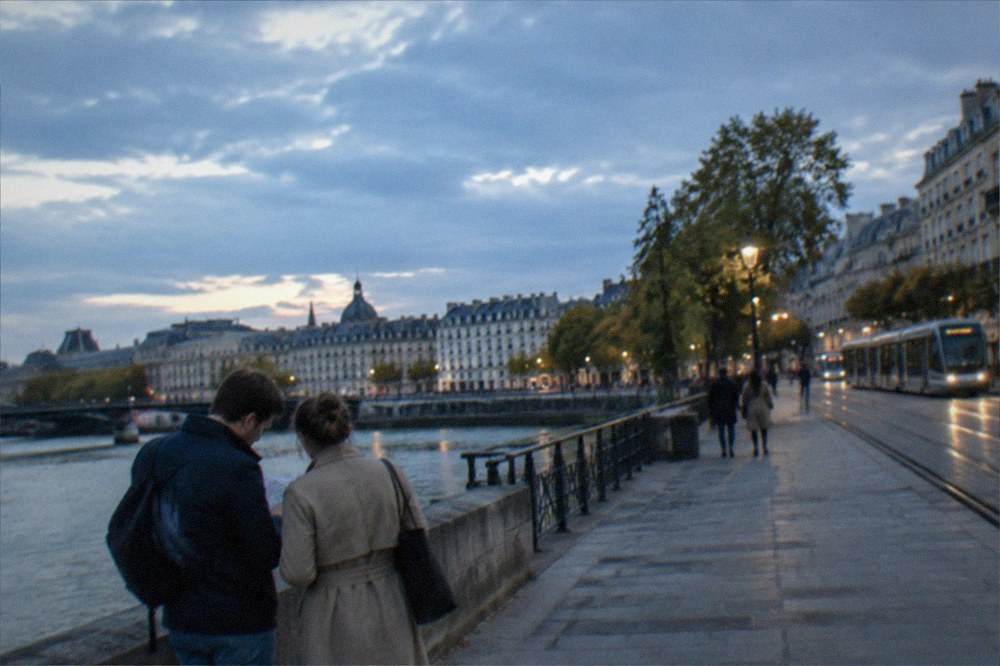 A couple consulting a map on a sunny square with cafe terraces in Nantes