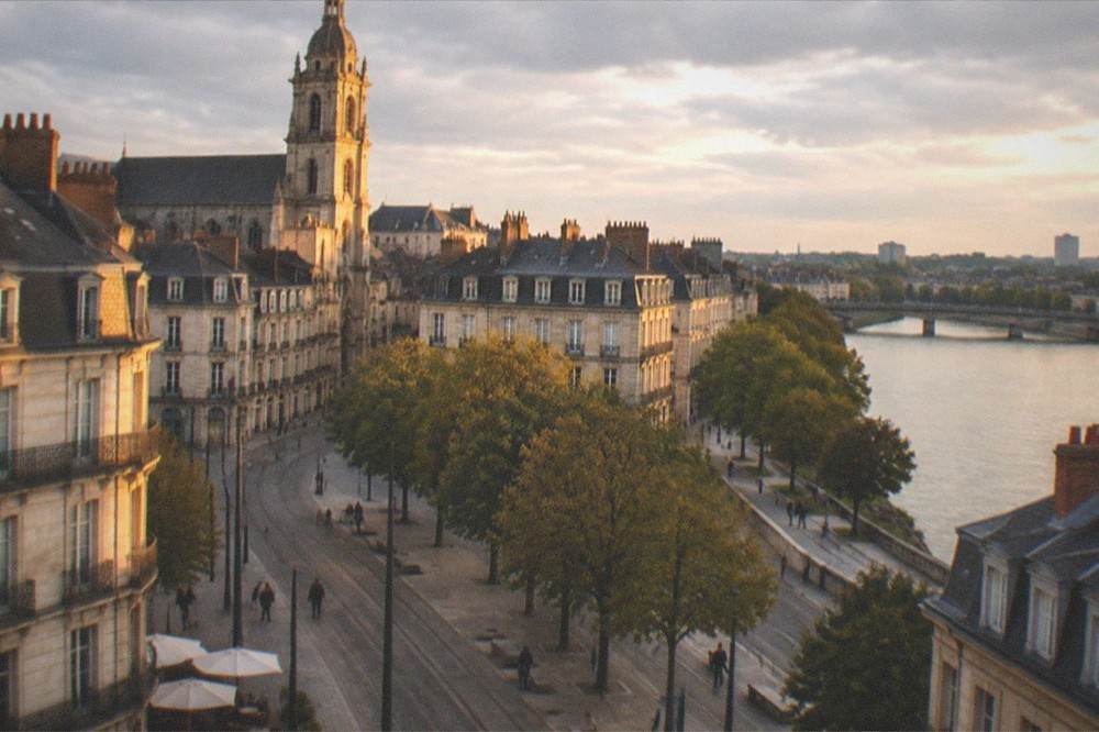 Evening light on historic stone facades and a church tower in the old town of Nantes