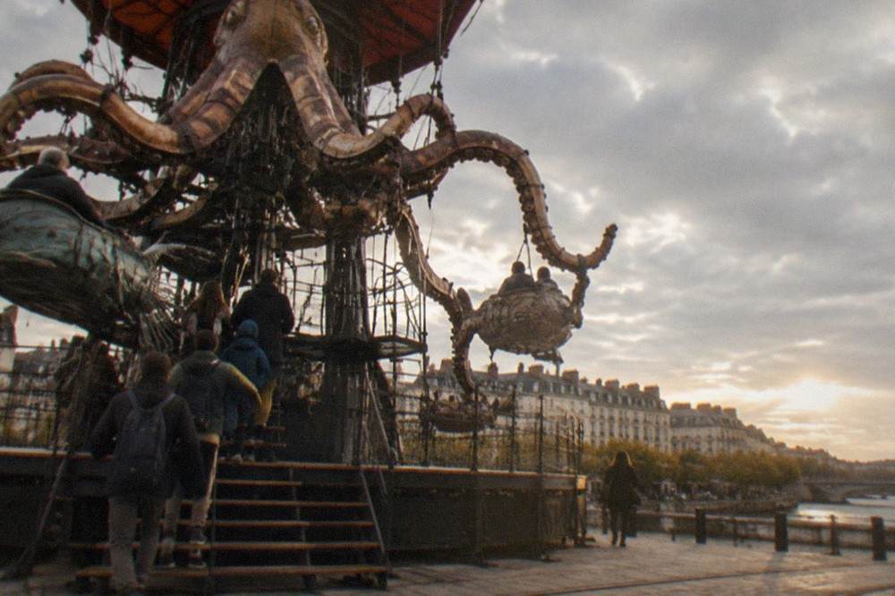 Riders boarding large articulated mechanical sea creatures on a carousel platform