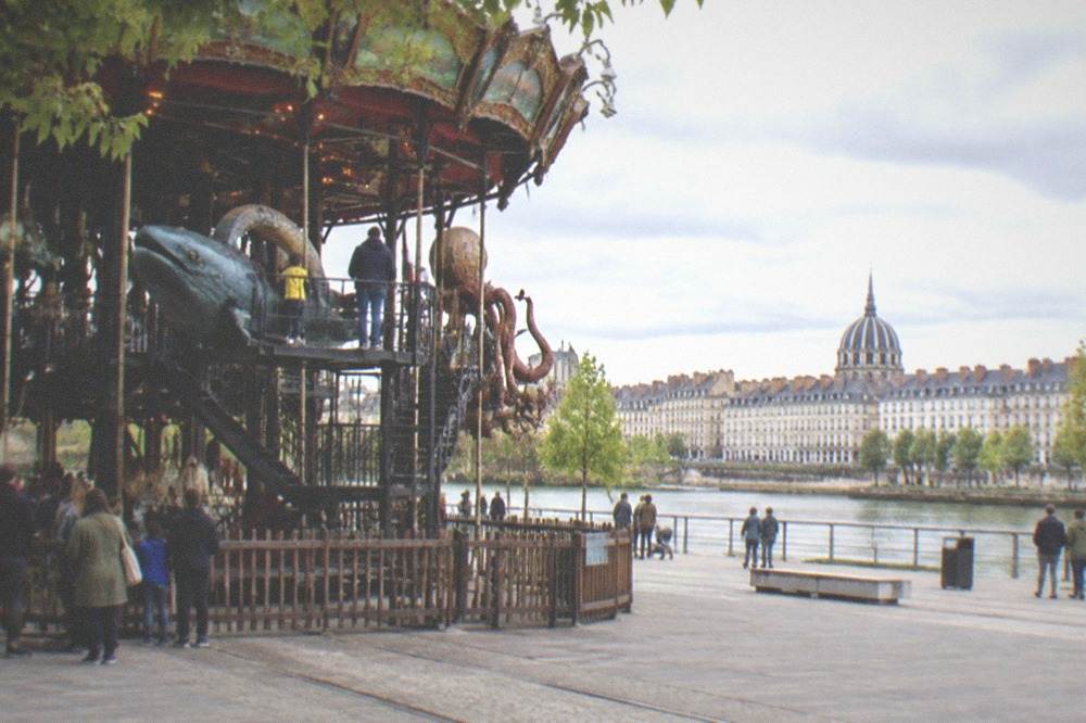 Families climbing onto mechanical sea creatures on the upper level of a carousel