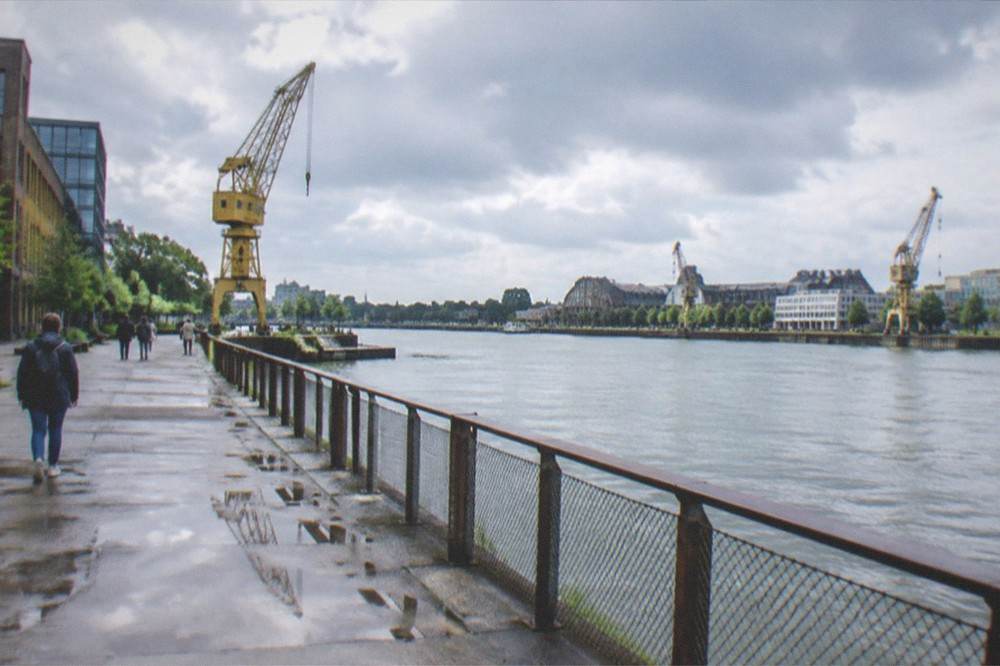 The Loire riverside on the Île de Nantes with cranes, walkers and the machine buildings in the distance