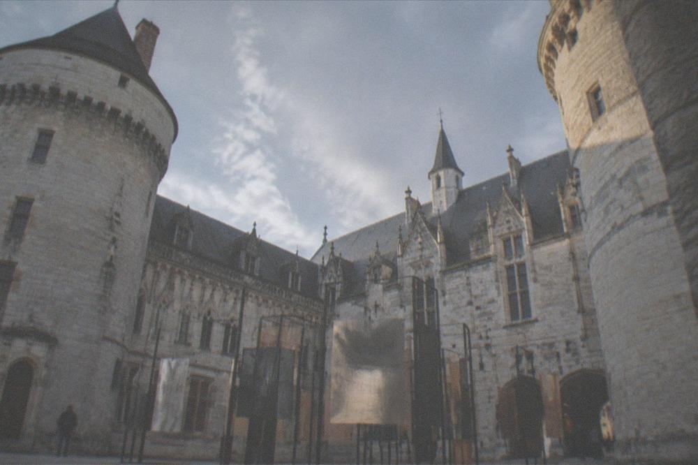 A gallery inside the château with contemporary artworks from the Expression(s) décoloniale(s) #4 exhibition, including large photographs and text panels.