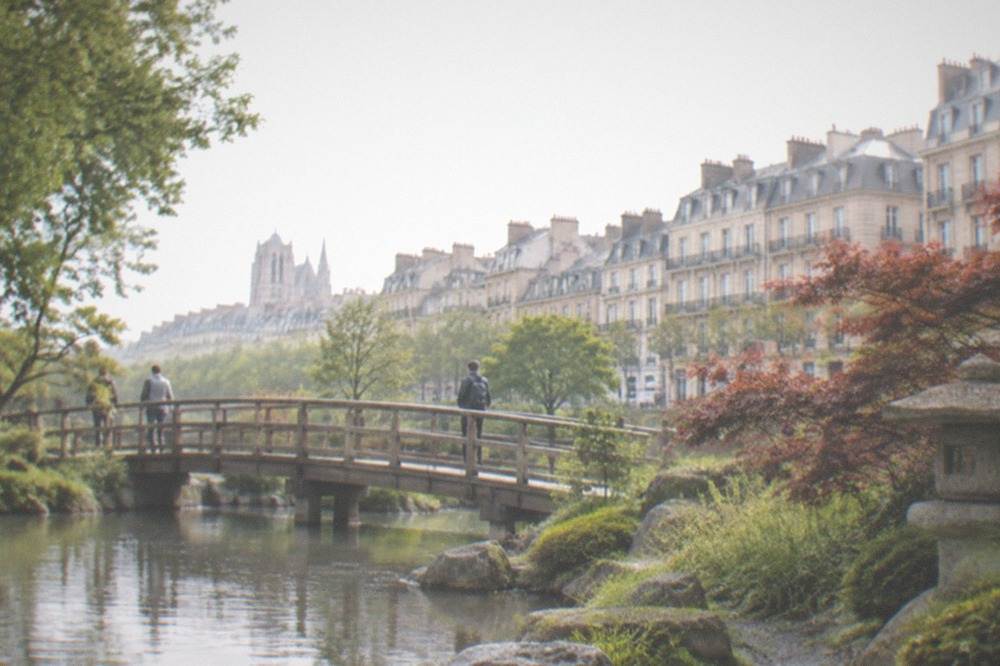 Japanese garden on a river island with stones, maples and a wooden bridge in Nantes