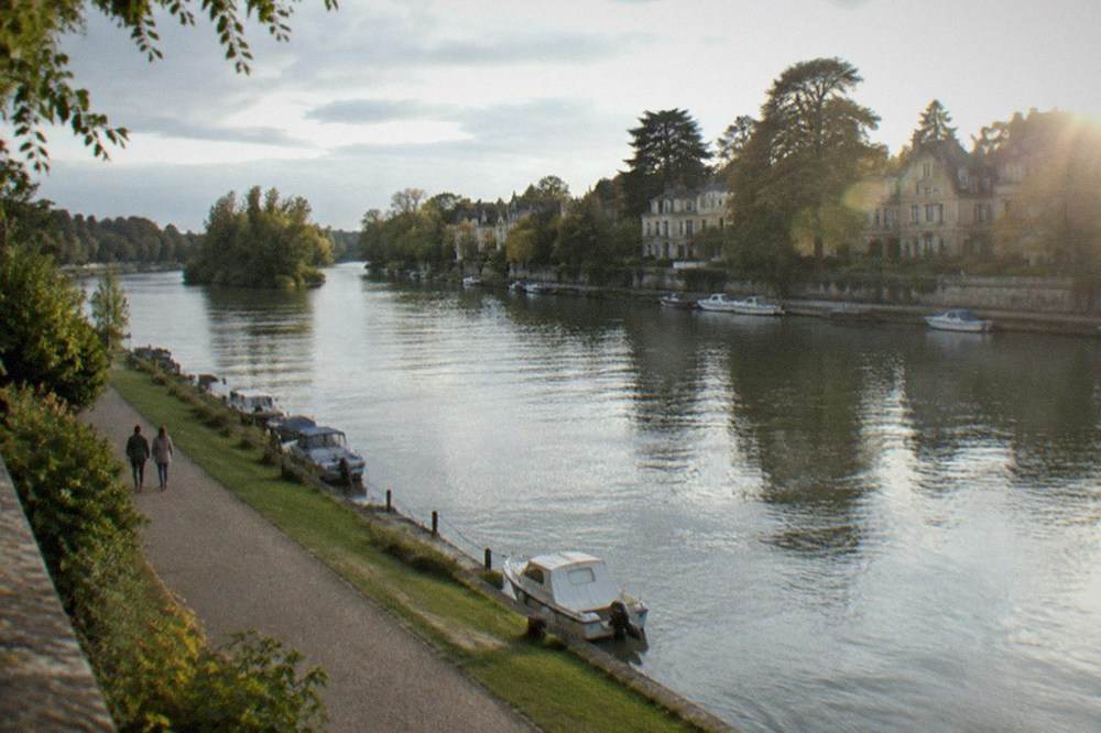 A walkway along the Erdre riverbank leading towards a garden island