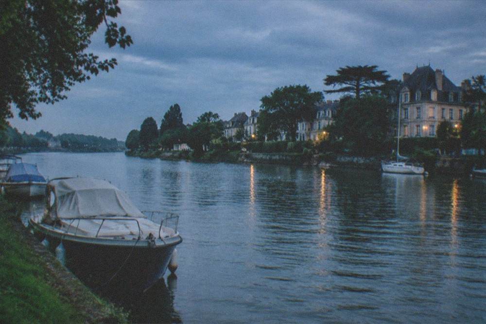 The Erdre riverbank in central Nantes with trees and moored boats in view