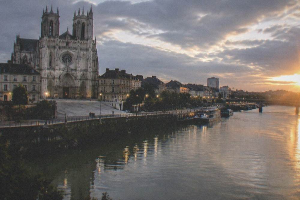 The lights of Nantes cathedral and riverside quays seen at dusk from the south bank of the Loire