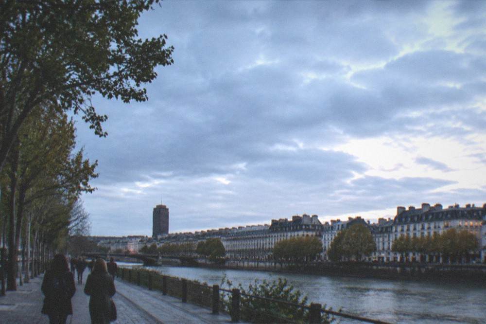 People strolling along a riverside quay with trees in central Nantes