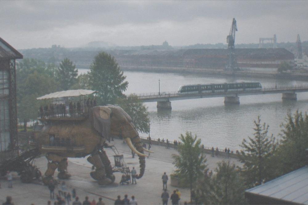 A tram crossing the Loire toward the Ile de Nantes with the old shipyard buildings beyond