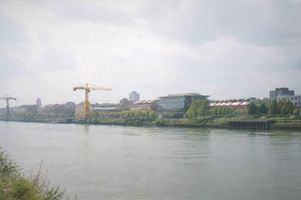 The riverside green spaces and workshop roofs of the Ile de Nantes seen from across the Loire