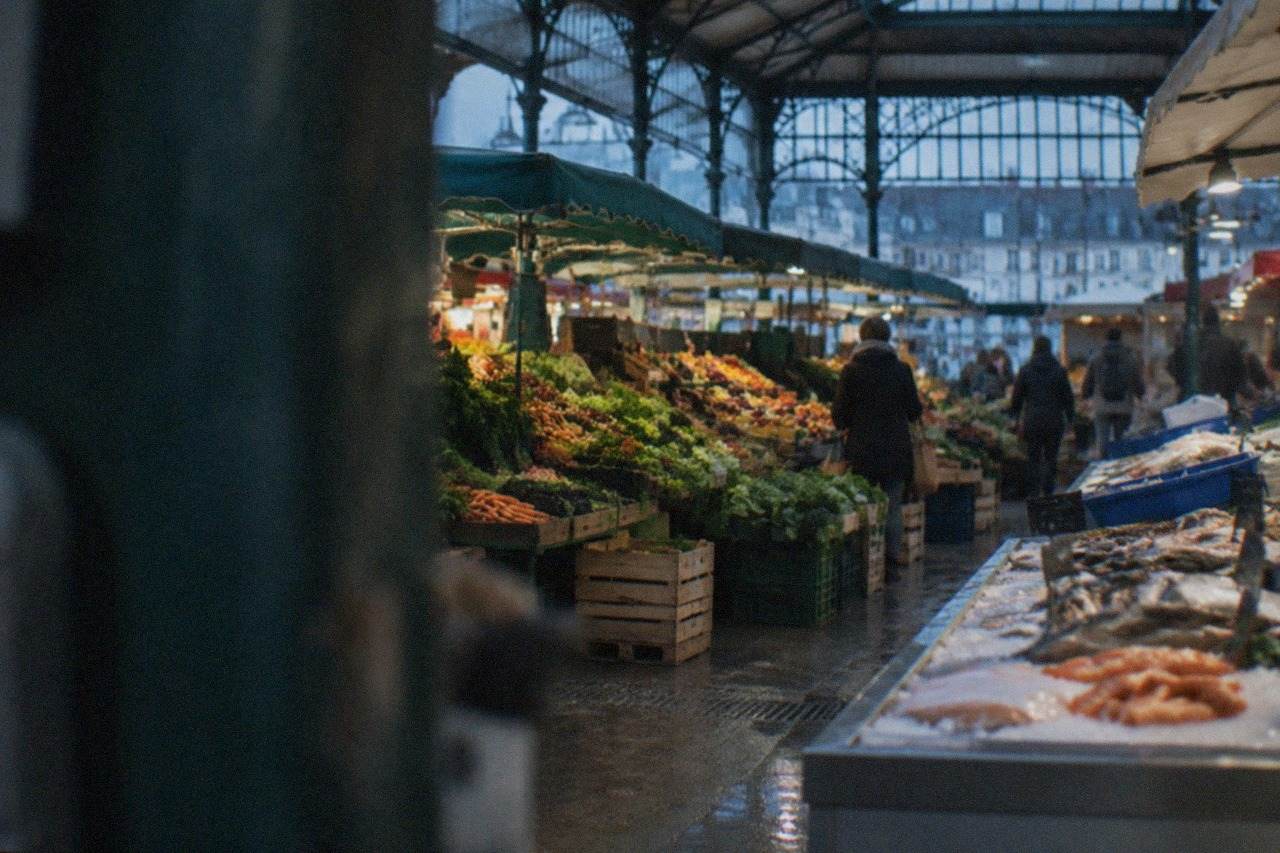 Market stalls with fresh vegetables and fruit under open awnings on a Nantes morning