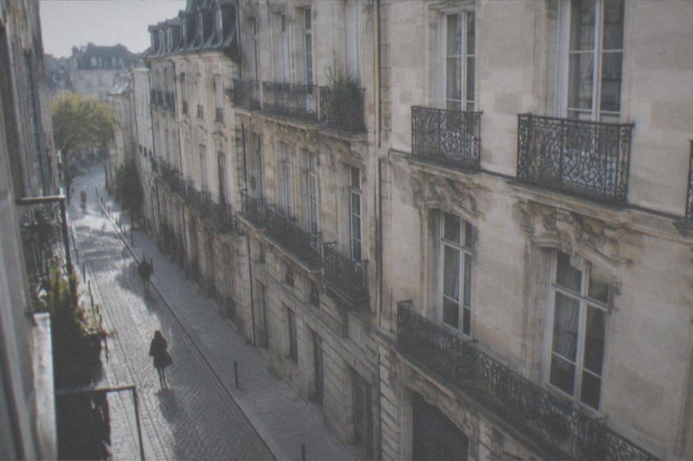 Historic stone facades of the Île Feydeau district in Nantes with ornate balconies above the street