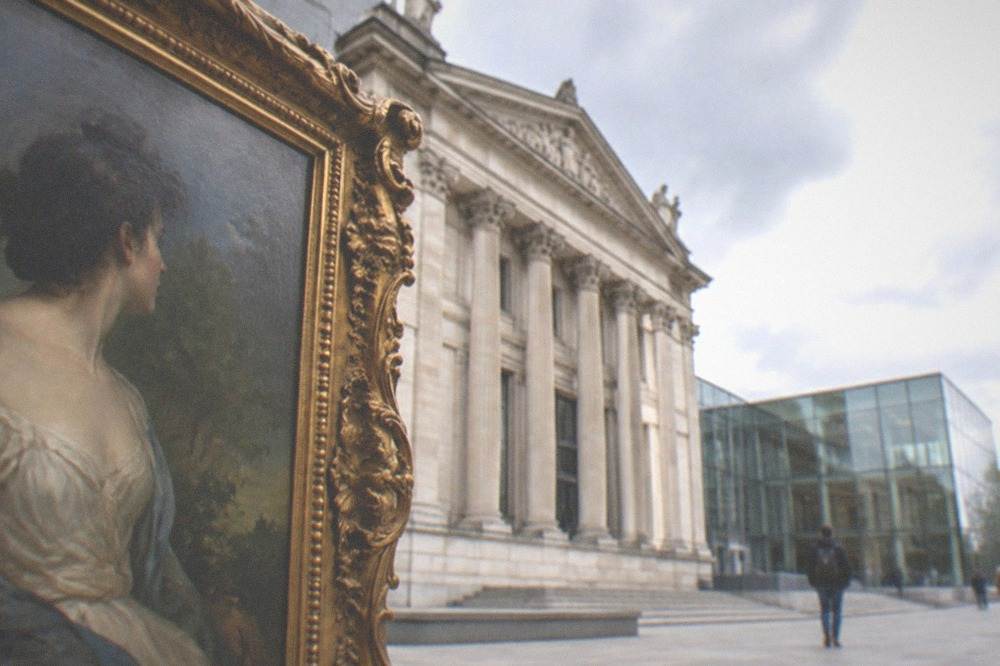 Close view of an ornate gilded frame around a classical portrait painting