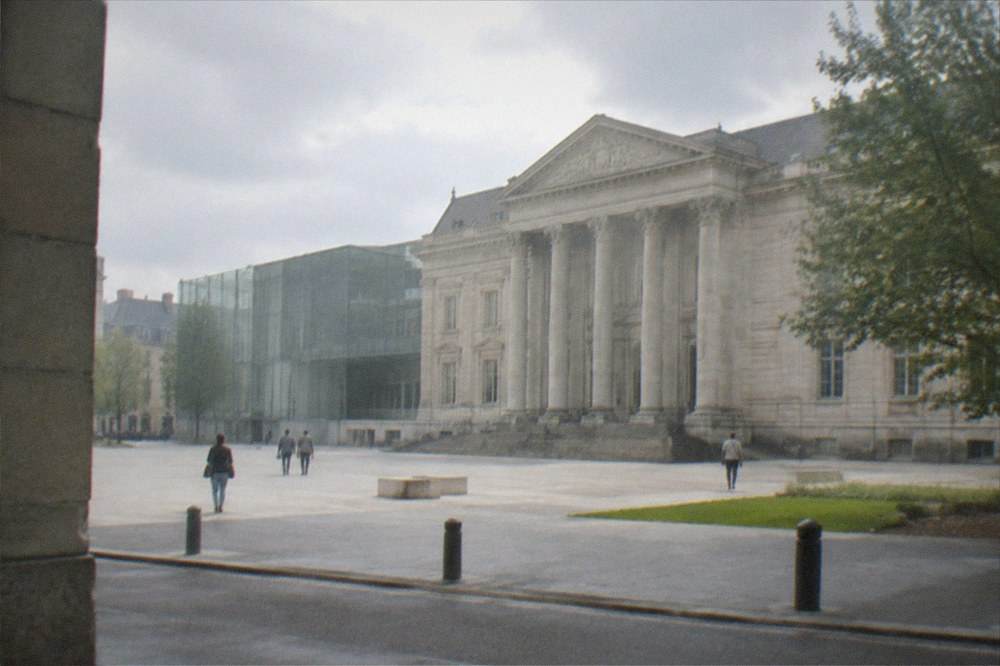 Facade of a stone museum palace with columns seen from a city street