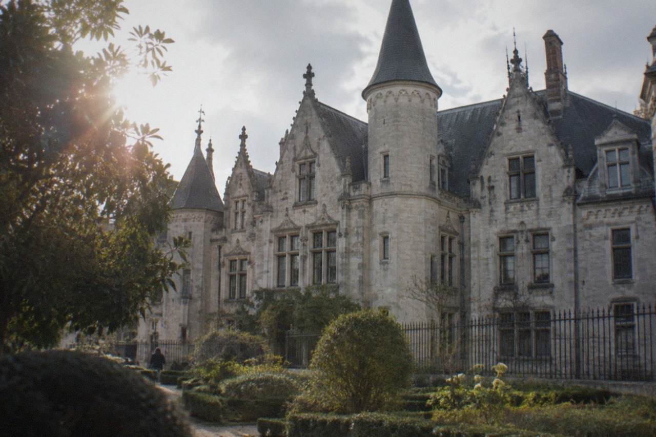 The stone facade of the Musée Dobrée museum in Nantes seen from its garden on a bright afternoon