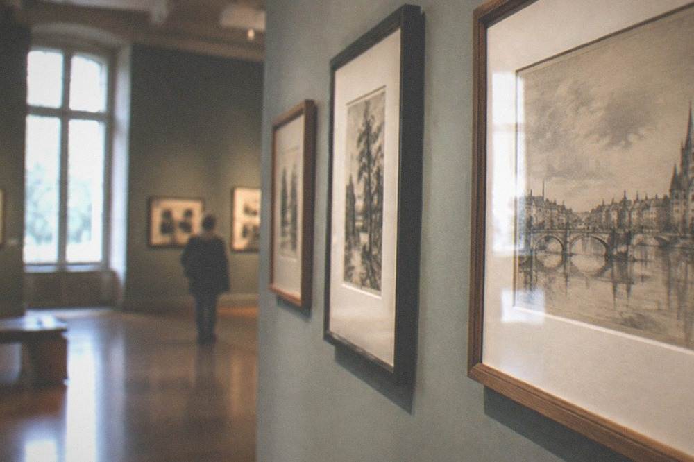 Framed drawings and prints hung in a softly lit exhibition room at the Musee Dobrée