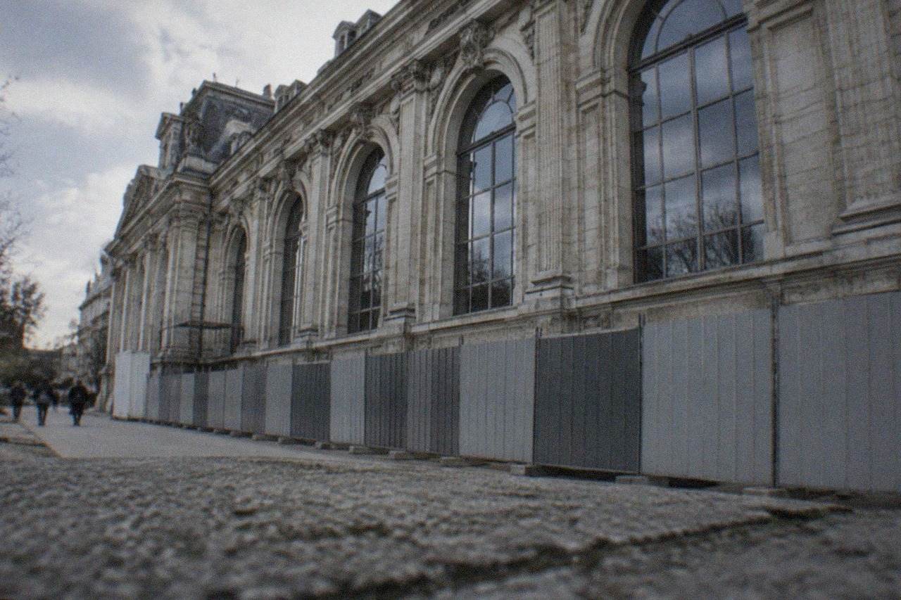 The stone facade of a city museum building behind construction hoarding in Nantes