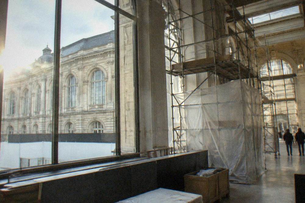 A bright gallery interior with scaffolding and protective sheeting during renovation works