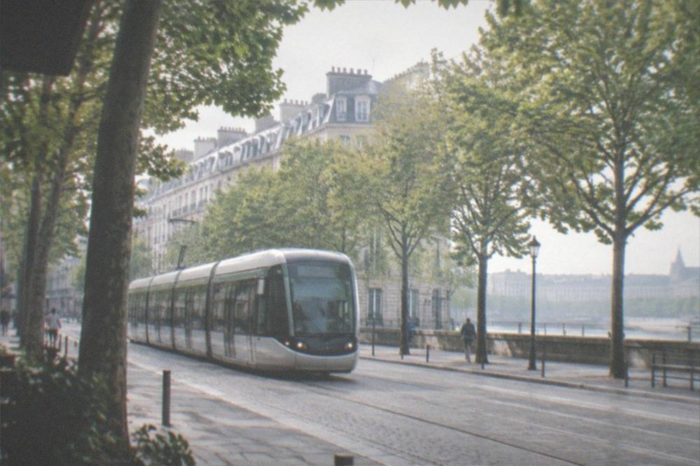 A Nantes tram passing a tree-lined street on a bright afternoon