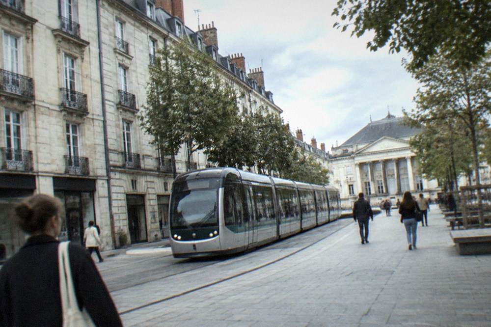 A tram moving through a pedestrianised shopping street near a classical square in Nantes