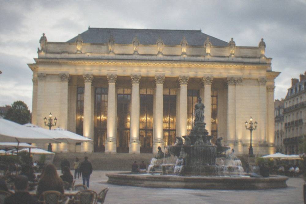 The Theatre Graslin facade lit at night above the fountain on Place Graslin