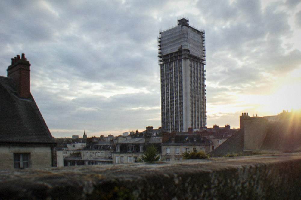 Scaffolding and protective sheeting covering a high-rise tower under renovation