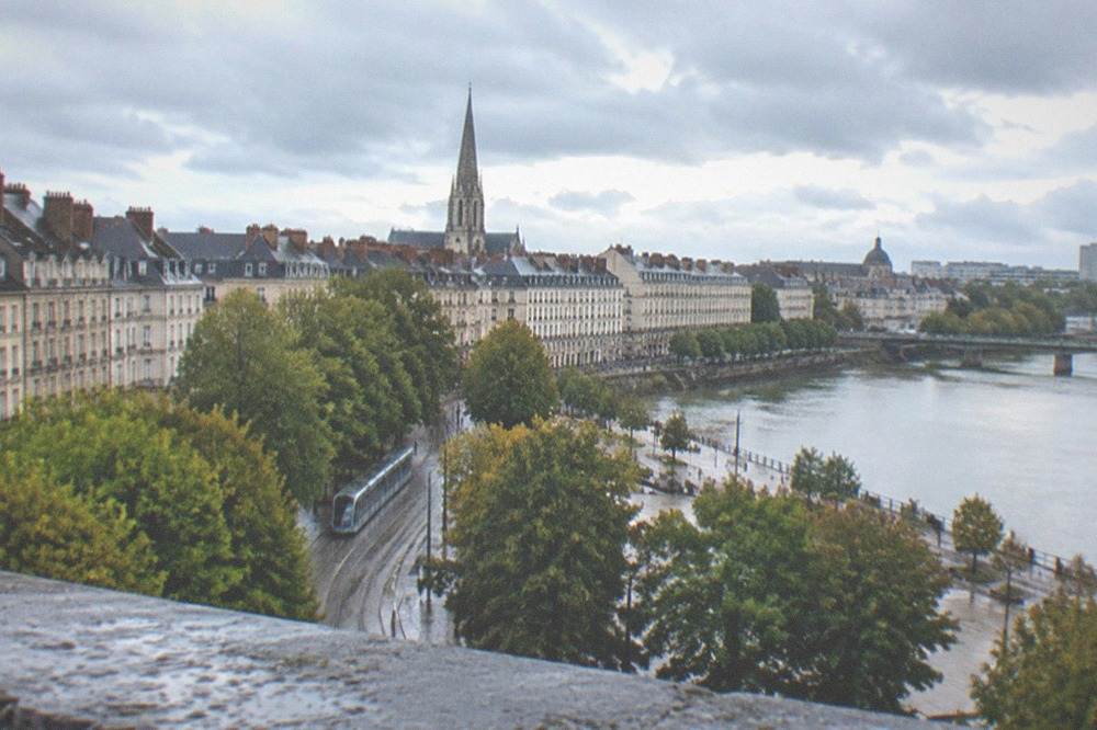 The Nantes skyline with a church spire and low grey rooftops seen from an elevated position