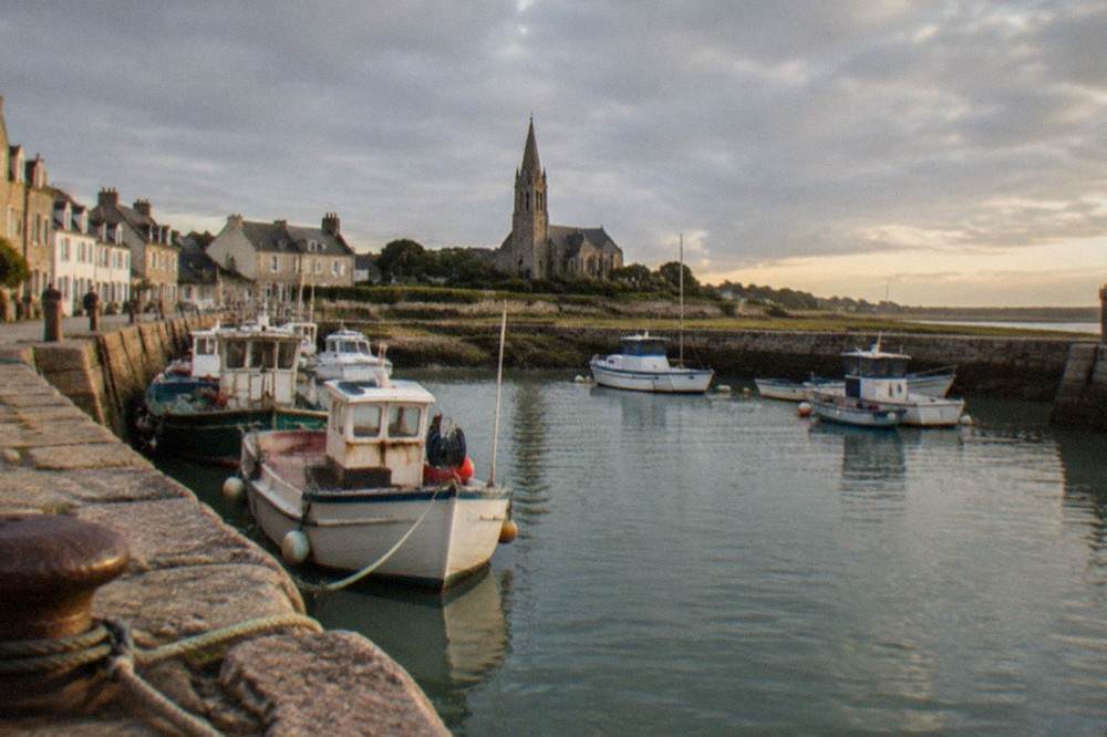 A granite church tower above the salt marshes and sea at Batz-sur-Mer