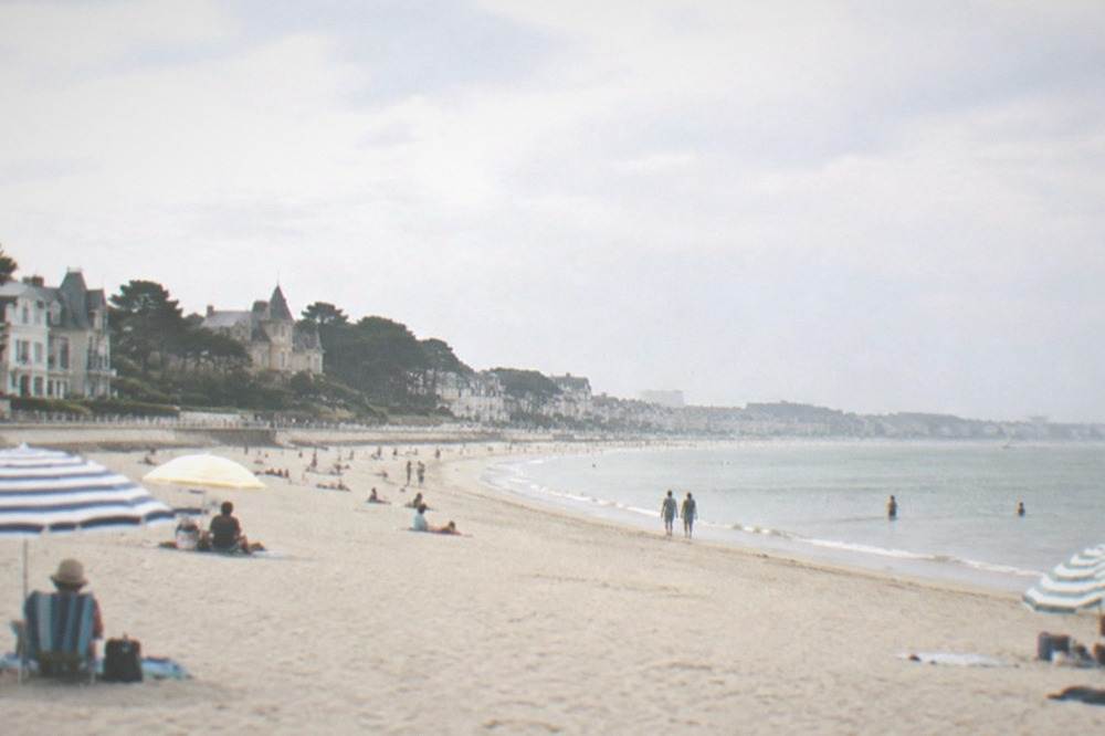 Wide sandy beach and promenade at La Baule with parasols and calm water